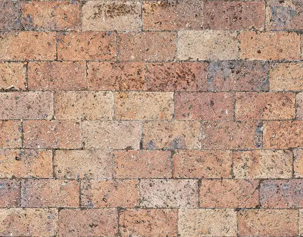 Close-up of weathered concrete block pavers laid in a stretcher bond