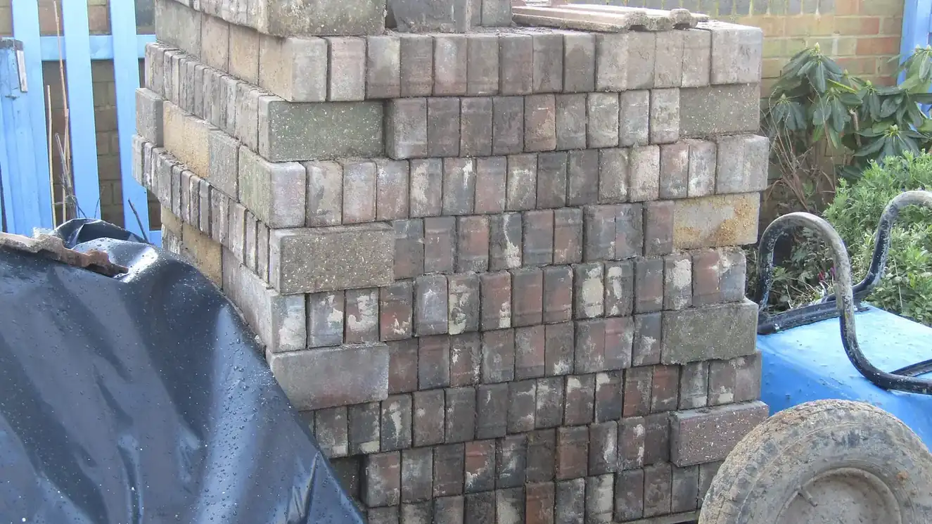 Driveway under construction with blocks being laid on a screeded sand bed, showing the stage of the job that sets the price